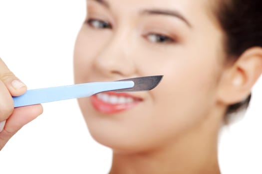 Cosmetic surgery concept. Female face in background of scalpel.