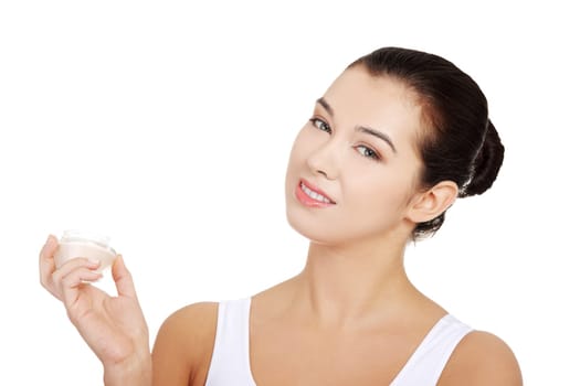 Woman applying lifting cream from container on face, isolated on white