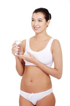 Fit young woman in underwear with glass of mileral water, isolated on white