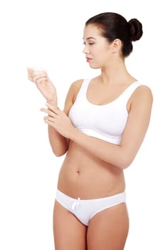 Woman applying lifting cream from container on face, isolated on white