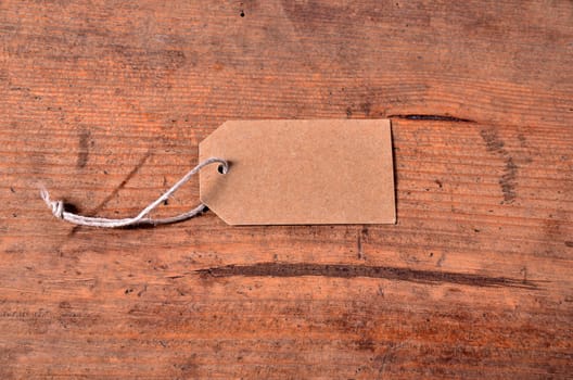 Cardboard pendant with ribbon empty on old wood