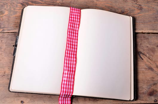 an old empty book on a wooden board background