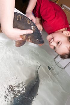 women with son touching christmas carp