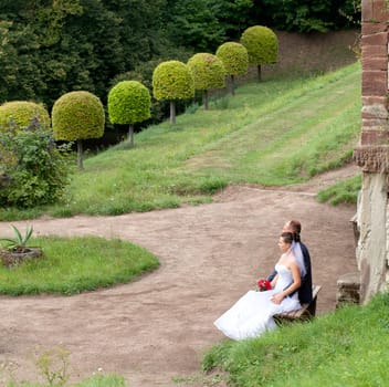 Wedding couple sitting on a bench