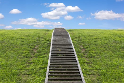 Staircase to heaven. Huge stairway leading up a green hill