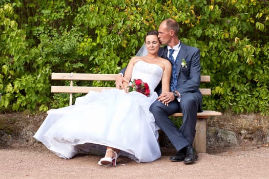 Wedding couple sitting on a bench