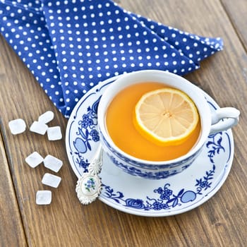 Black tea with lemon in a cup with candy sugar