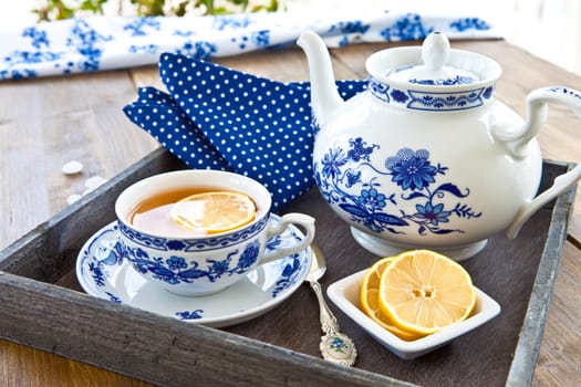 Tea in porcelain dishes with fresh lemon