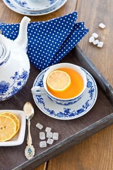 Tea in porcelain dishes with fresh lemon