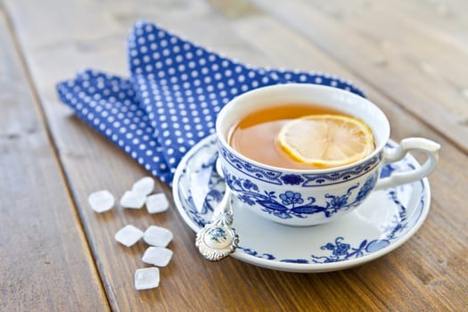 Black tea with lemon in a cup with candy sugar