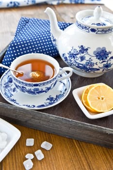 Tea in porcelain dishes with fresh lemon