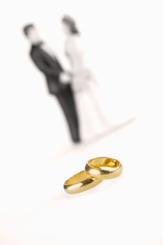 Pure gold wedding rings with wedding couple background