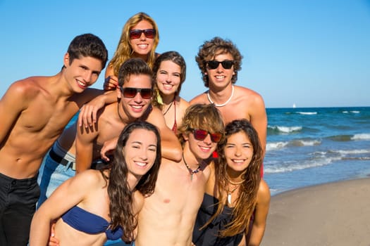 Happy teenagers young group together on beach in summer vacations
