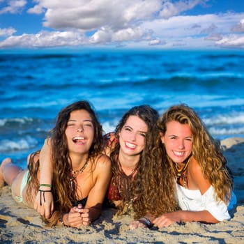 Girls group friends having fun happy lying on the beach sand shore