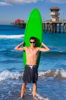 Boy teen surfer holding surfboard in Huntinton Beach pier California