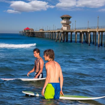surfers waiting for the waves on Huntinton beach pier California