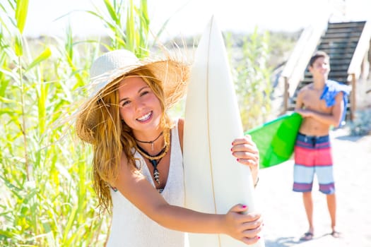 Teenager surfers walking to the beach in sunny summer day