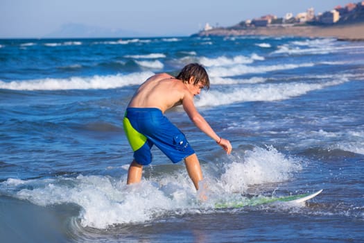 Boy surfer surfing waves on the beach enjoying fun