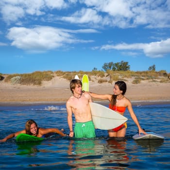 Happy beautiful teen surfers talking on beach shore smiling