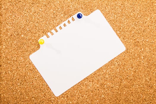 Cork board with blank paper pinned up.