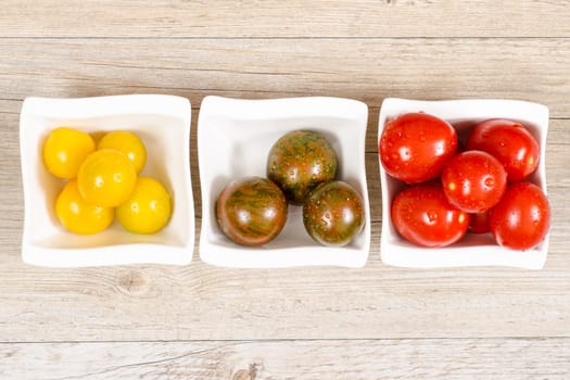 Various cocktail tomatoes in yellow,green and red in one bowl