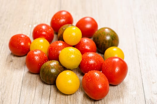 Various cocktail tomatoes in red,yellow and green on one board