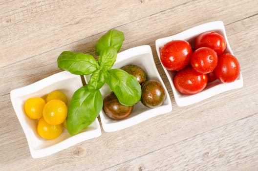 Various wet tomatoes in peels and basil
