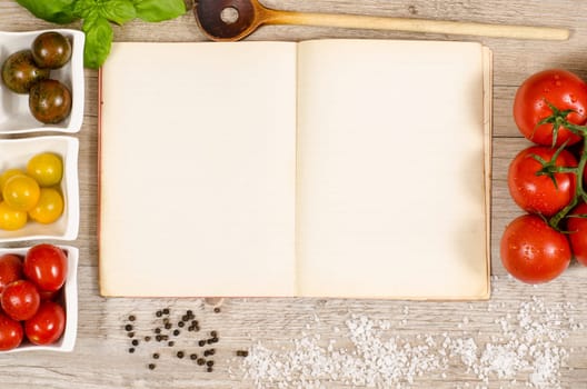 Vintage book and paper with test space for recipe with ingredients on wood