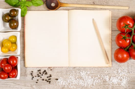 Old book with advertising space with pencil,cooking spoon,pepper,salt and tomatoes