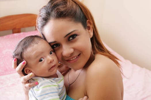 Portrait of a beautiful hispanic happy mother with smiling baby