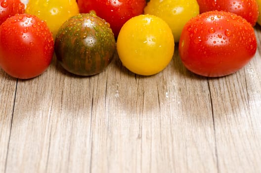 Colorful tomatoes on a wooden board with text space