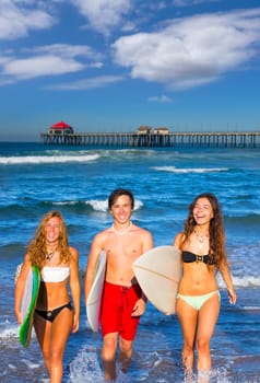 boys and girls teen surfers coming out from the Huntington beach California