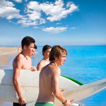 Surfer teen boys talking on beach shore holding surfboards