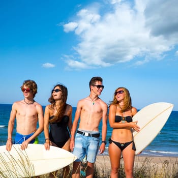 Boys and girls teen surfers happy smiling over dune beach in summer