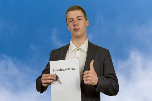 Young man holds a leasing contract in his hands and is happy