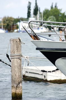 The photograph of a ship's bow tied to a wooden pole.
