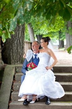Wedding couple sitting in the castle park