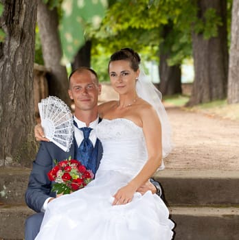 Wedding couple sitting in the castle park