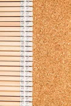 Bunch of wooden pencils over a cork board.