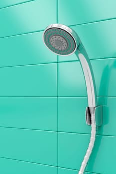 Chrome shower head on green tiles