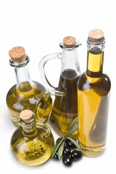 Jars with olive oil and some olives isolated over a white background.