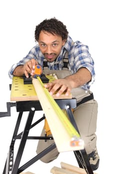 Carpenter carefully measuring plank of wood