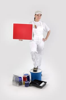 Female decorator stood with red poster