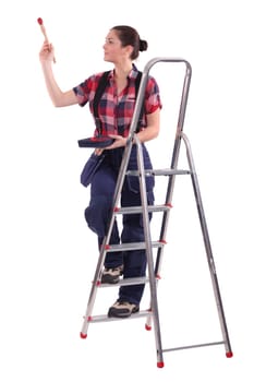 Female decorator climbing a ladder