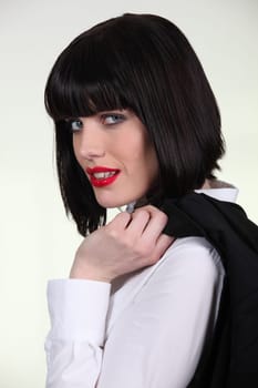 Elegant woman carrying jacket on her shoulder
