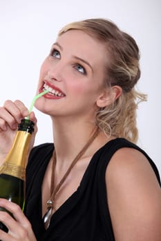 Woman drinking champagne through a straw