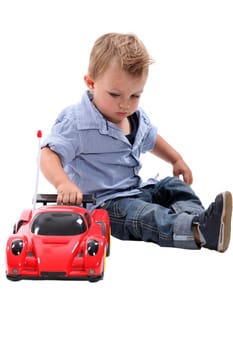 Young boy playing with a toy car