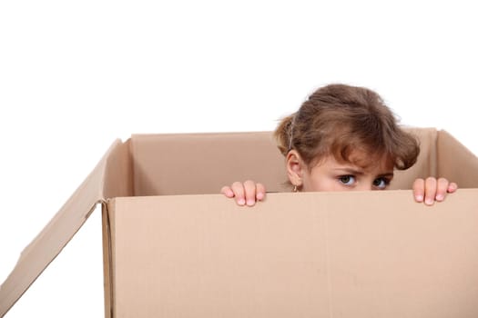 Little girl playing in a cardboard box