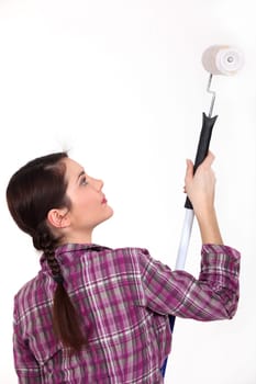Woman using paint roller and extension