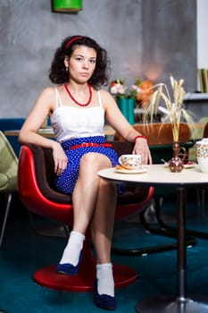 Woman in café with evaluative look on face